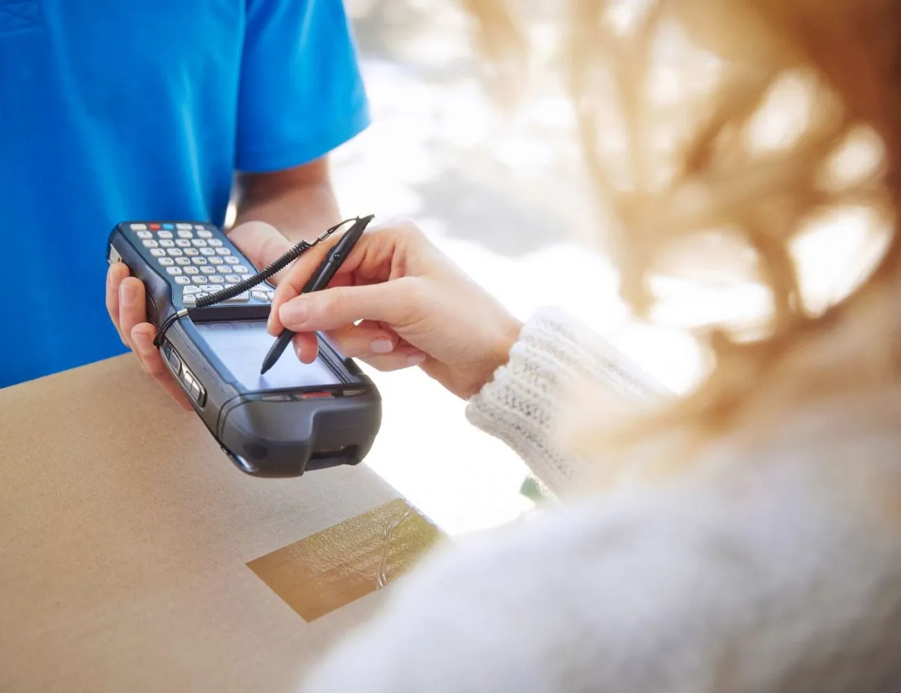 Femme qui signe sur le PDA scanner du chauffeur livreur 