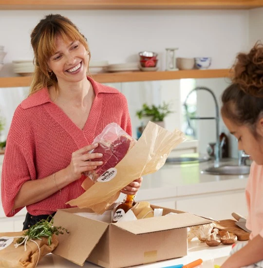 Mère et fille déballant un colis alimentaire 
